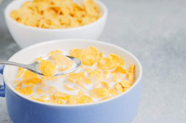 Photo corn flakes in milk. blue cup. healthy and nutritious breakfast for a child.