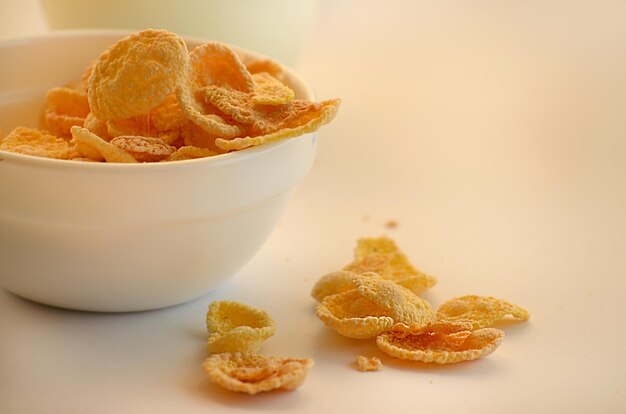 Corn flakes and milk on white background