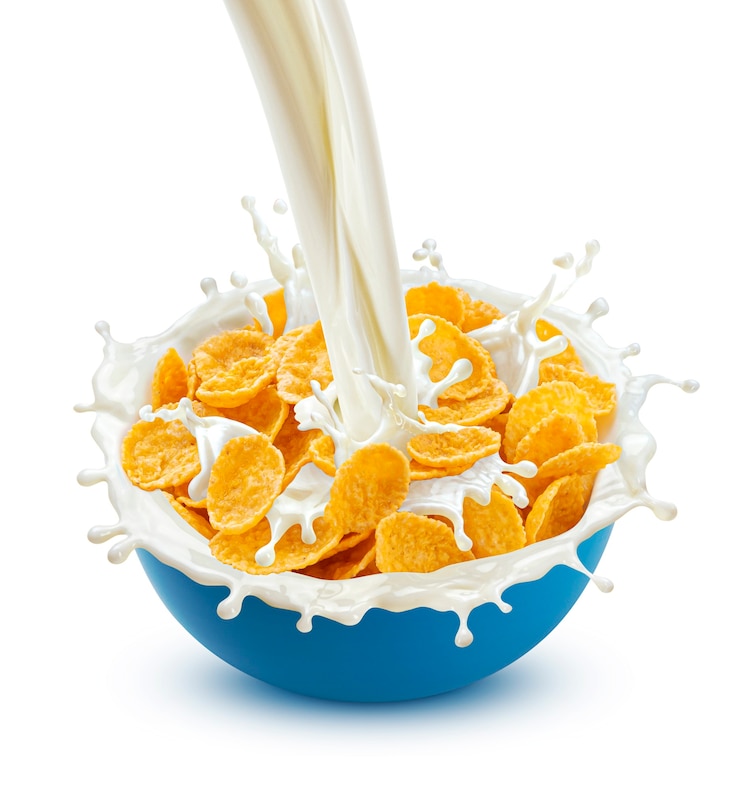 Photo corn flakes with pouring milk isolated on white background