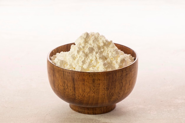 Photo corn flour in wooden bowl close up