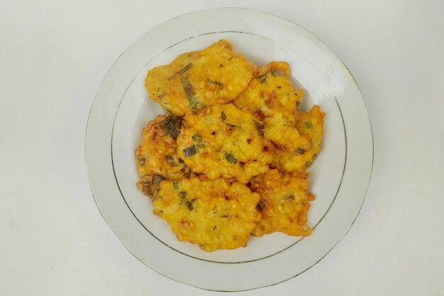 Corn fritters are served on a white plate on the table