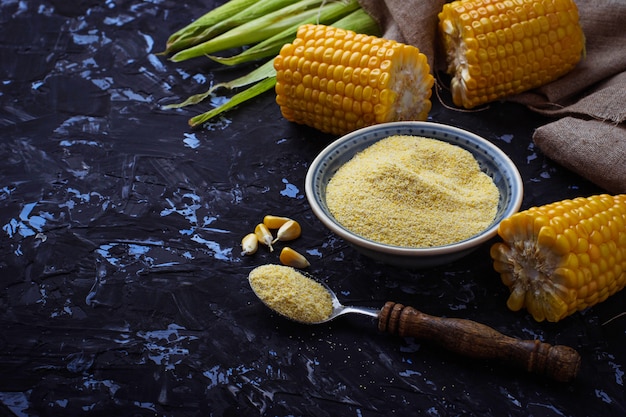 Corn grits and corncob on concrete background. selective focus