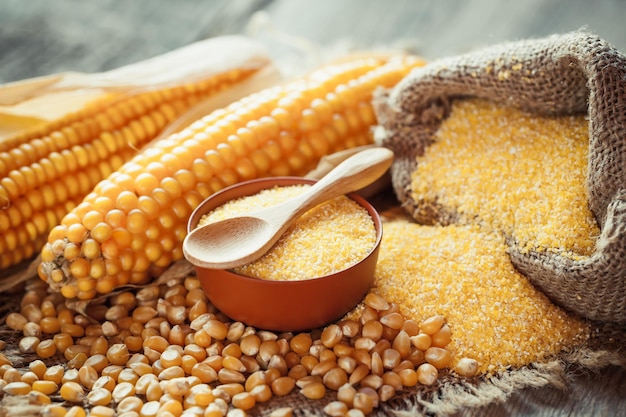 Corn groats and dry seeds corncobs on wooden rustic table Selective focus