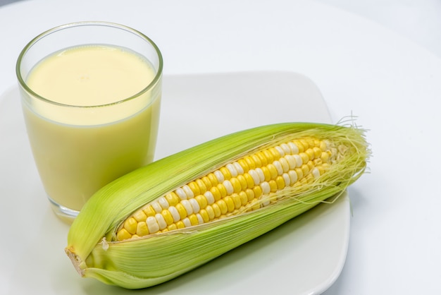 Photo corn milk in glass on white background.