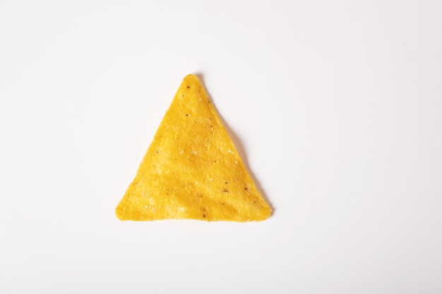 Corn nacho chips are triangular in shape on a white background Mexican snack