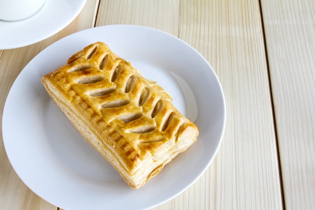 Corn pie and coffee cup on wooden background.