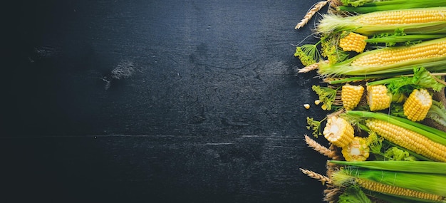 Corn Raw Vegetables On a black wooden background Top view Free space for your text