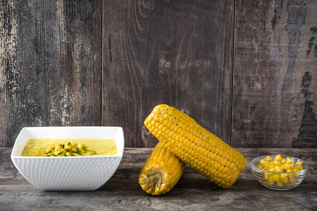 Photo corn soup in bowl on wooden