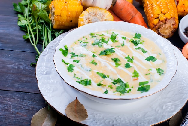 Corn soup in a ceramic plate and ingredients