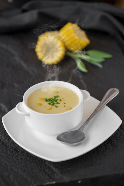 テーブルに白いカップでトウモロコシのスープ