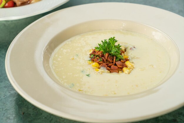 corn soup with crispy bacon on plate