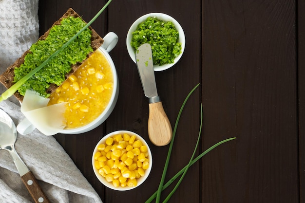 Corn soup with fresh garlic pate in white bowl healthy food on wooden background vegan cuisine