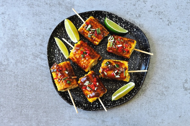 Corn on sticks with chili lime sauce.