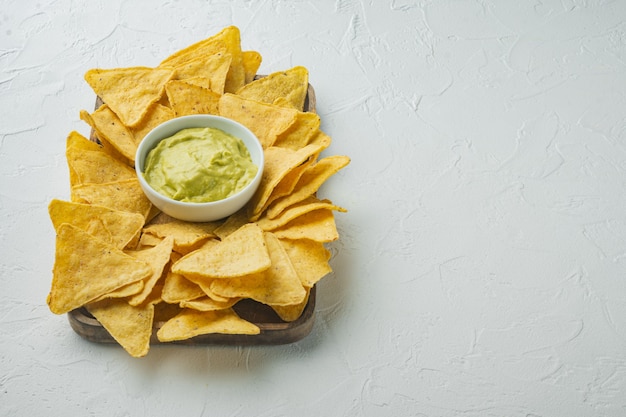 Corn tortilla chips nachos and dip sauce, on white table