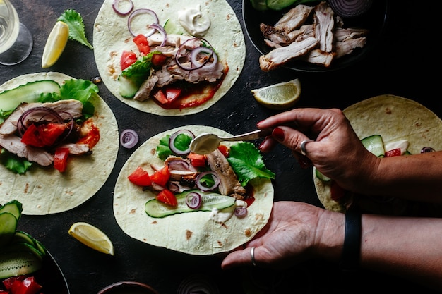Corn tortillas stuffed with chicken and vegetables on a wooden table Cooking tacos