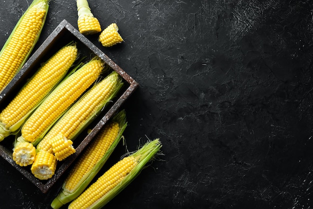 Corn in a wooden box. Vegetables. Top view. Free copy space.