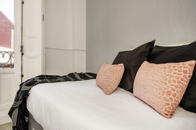 Corner of a bedroom with a youth bed with red cushions and stoneware walls