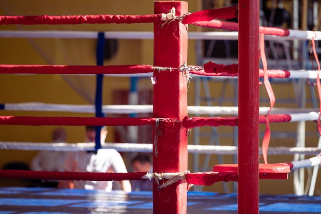 The corner of the boxing ring is large The image has a shallow depth of field with focus at the point where the ropes are attached to the rack