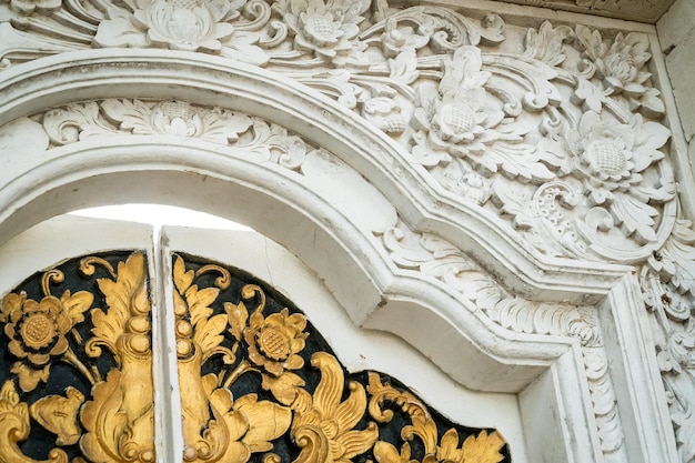 地元の大工によって木製のドアに刻まれた伝統的なバリの装飾品の角の断片。地元の伝統と職人技のコンセプト