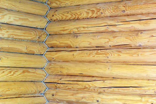 Corner of the house is built from wooden logs and entwined rope 