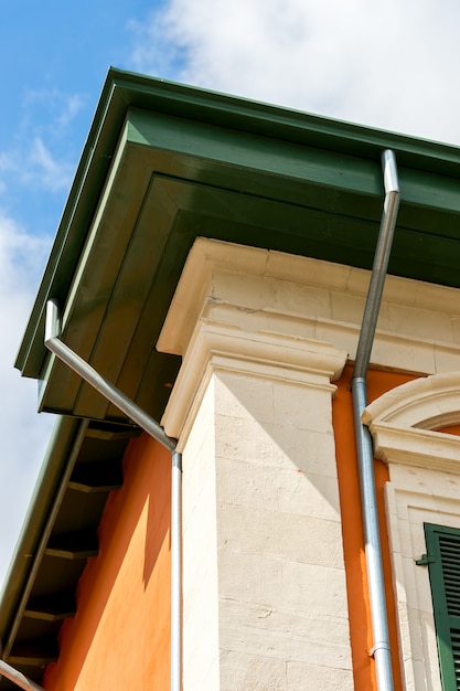 Corner of the house with a drain pipe