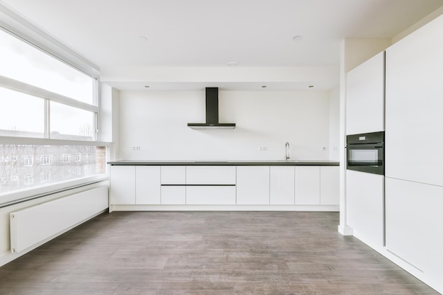 Corner kitchen of a light shade in a minimalist style in a studio apartment