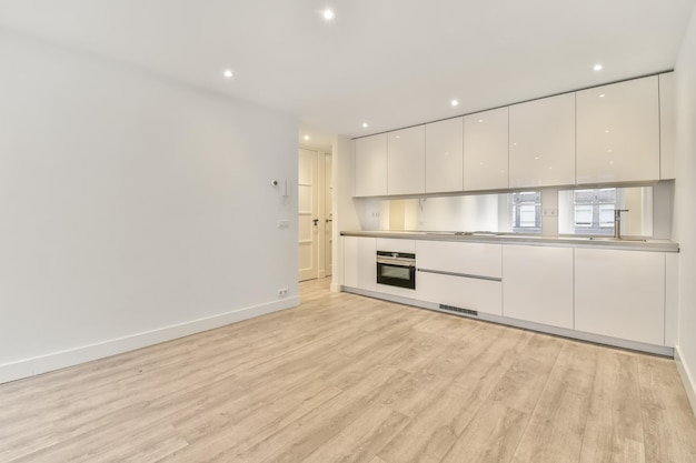 Photo corner kitchen in white tones in a minimalist style in a studio apartment