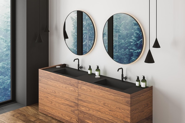 Угол современной ванной комнаты с белыми и серыми стенами, деревянным полом, двойной раковиной и двумя круглыми зеркалами. Окно с размытым видом 3d-рендеринг