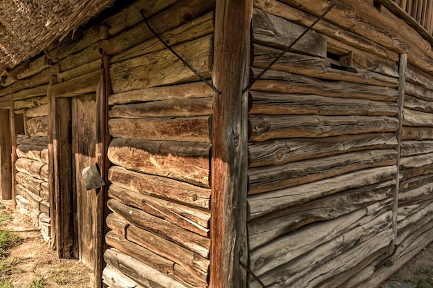 Corner of an old old house in a Ukrainian village. Felled from unpainted planed debarked horizontal wooden logs. Log cabin.