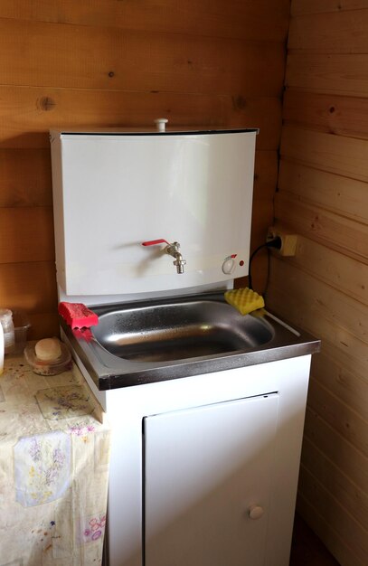 시골 집에서 손과 접시를 는 모이, 싱크대, 스폰지 및 비누가 있는 금속 전기 세탁기