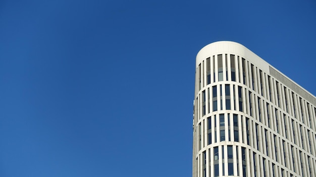 Corner of white skyscrapers against blue sky