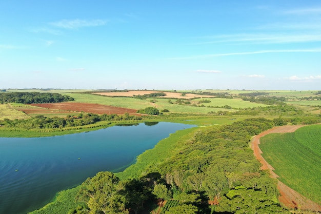 Cornfield and dirt road beside a river seen from above