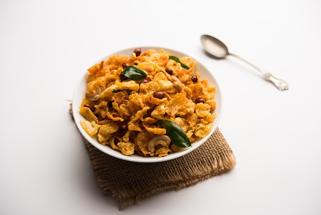 Cornflake Chivda or Corn Chiwda loaded with peanuts and Cashew. Served in a bowl. selective focus