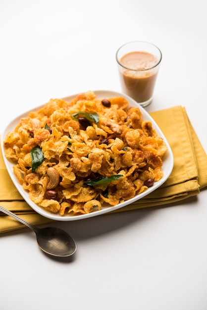 Cornflake Chivda or Corn Chiwda loaded with peanuts and Cashew. Served in a bowl. selective focus