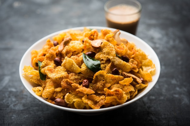 Cornflake Chivda of Corn Chiwda geladen met pinda's en cashewnoten. Geserveerd in een kom. selectieve focus