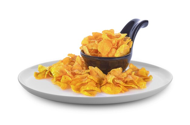 Cornflakes in black spoon on white background