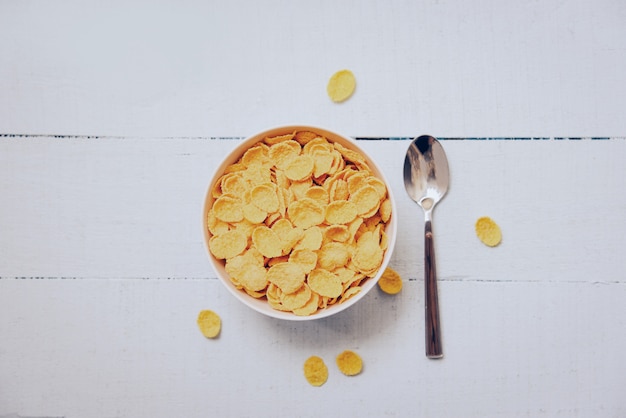 Foto colazione cornflakes in ciotola e cucchiaio - cereali cibo sano