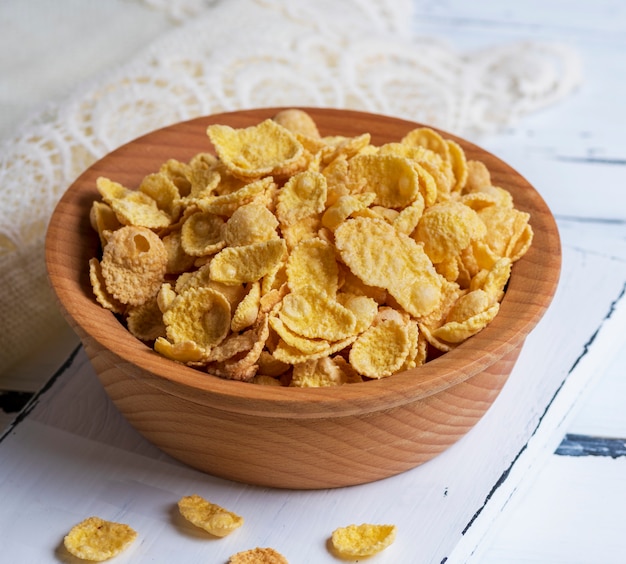 Cornflakes in a brown wooden bowl