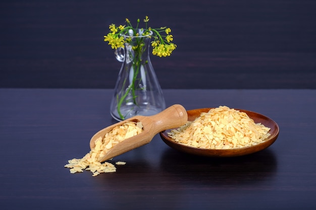 Cornflakes in houten lepel op een donker hout