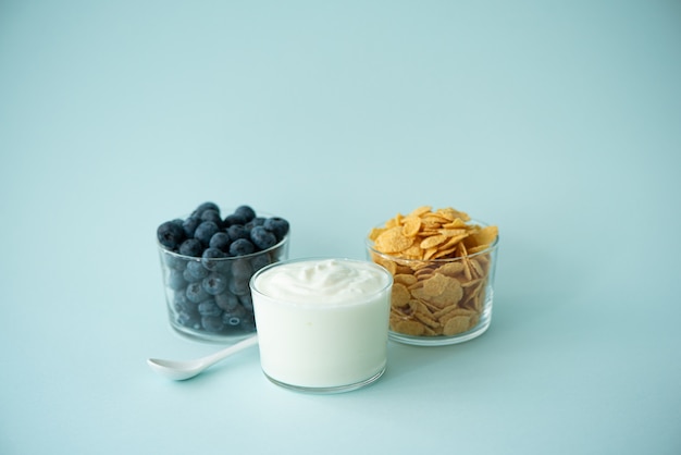 Cornflakes met Griekse yoghurtmelk en bessen op een blauwe achtergrond