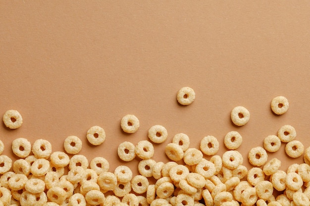 Cornflakes rings for breakfast on a brown background