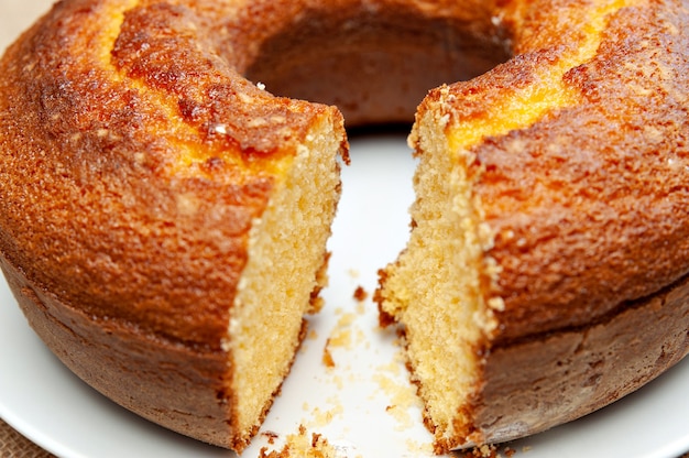 Cornmeal Cake (Bolo de Fuba) gesneden Braziliaanse stijl op een witte plaat. Geïsoleerd op jute. Vooraanzicht. Detailopname. Horizontaal schot.
