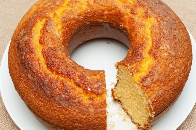 Cornmeal Cake Bolo de Fuba gesneden Braziliaanse stijl op een witte plaat geïsoleerd op jute