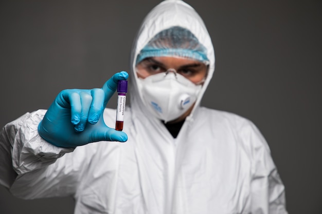 Coronavirus 2019-nCoV Blood Sample. Corona virus outbreaking. Epidemic virus Respiratory Syndrome. Man in protective clothes holding blood test.