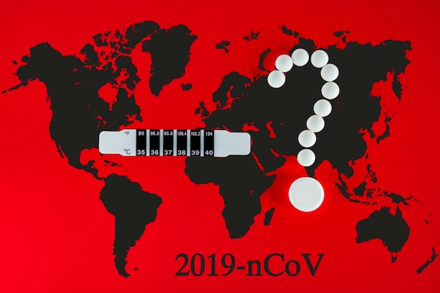 Coronavirus 2019-ncov nieuw coronavirusconcept dat verantwoordelijk is voor de uitbraak van aziatische griep als pandemie van gevaarlijke griepstammen. witte pillen in formulier vraagteken, thermometer, aarde op rood.