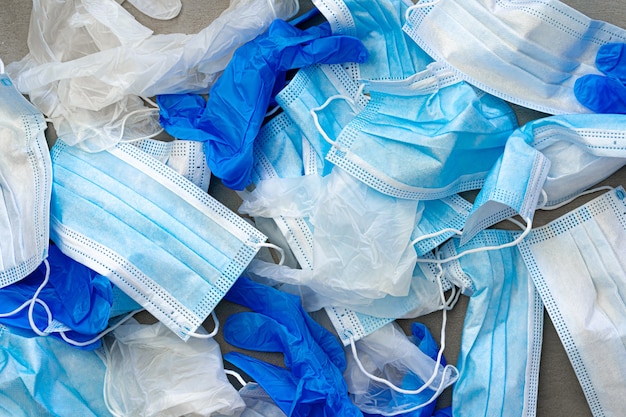Coronavirus-beschermingsapparatuur in medische afvalbak gebruikte gezichtsmaskers en steriele handschoenen
