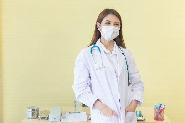 Coronavirus-beschermingsconcept Een Aziatische vrouwelijke arts die met zakkenroller staat