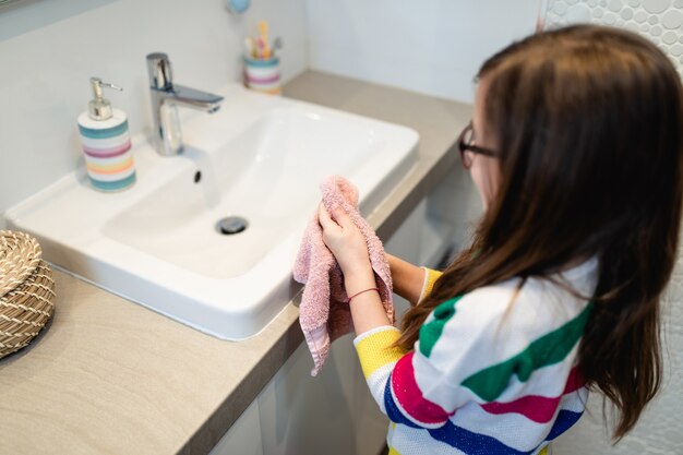 Concetto di coronavirus covid-19. ragazza che si lava le mani in bagno con sapone antibatterico.