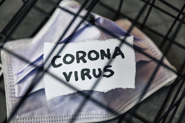 Foto coronavirus covid-19 corona tekst op papier in de kooi uitbraak virus epidemie quarantaine masker