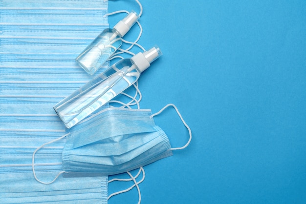 Coronavirus COVID-19 pandemisch concept - achtergrond gemaakt van antivirale chirurgische beschermende medische maskers en alcohol handdesinfecterend antiseptisch middel voor bescherming tegen coronavirus.